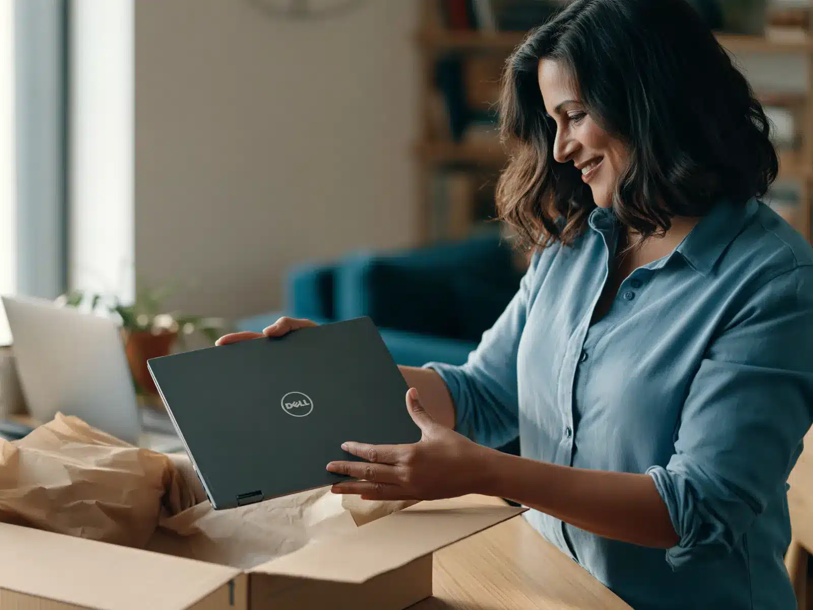 A donor packs her old laptop into a box to donate it